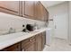 Well-equipped laundry room featuring ample cabinetry, sink, and modern appliances at , Las Vegas, NV 89149