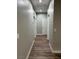 Hallway view, with neutral walls and wood-look floors, leading to doorways at 1060 Hall Ave, Pahrump, NV 89048