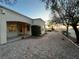 A clean backyard with desert landscaping, stone, and a stucco house with neutral paint and nice window coverage at 10717 Grand Cypress Ave, Las Vegas, NV 89134