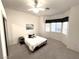 A bright bedroom features neutral paint, carpet, and a ceiling fan, plus large windows for ample natural lighting at 10717 Grand Cypress Ave, Las Vegas, NV 89134
