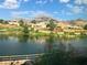 Scenic lake view home featuring lush landscaping, mountain views, and vibrant flora in a serene community at 10717 Grand Cypress Ave, Las Vegas, NV 89134