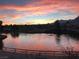 Picturesque lake view with vibrant sunset reflecting on the water and surrounding landscape at 10717 Grand Cypress Ave, Las Vegas, NV 89134