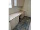 Laundry room features tile floors, cabinets, countertops, and a window at 10717 Grand Cypress Ave, Las Vegas, NV 89134