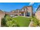 The backyard features a well-maintained lawn, a covered patio, and views of the house's exterior at 10979 Bristol Park Ave, Las Vegas, NV 89166