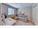 This bedroom features a comfortable gray couch, a functional desk, and neutral decor at 10979 Bristol Park Ave, Las Vegas, NV 89166