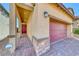 Close-up of home showcasing brick accents, a red door, and a matching brick driveway at 10979 Bristol Park Ave, Las Vegas, NV 89166