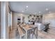 Bright kitchen boasts modern gray cabinets, stainless appliances, and a wooden dining table set for six at 10979 Bristol Park Ave, Las Vegas, NV 89166