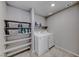 Bright laundry room with washer, dryer, and shelving for organized storage of supplies at 10979 Bristol Park Ave, Las Vegas, NV 89166