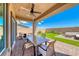 Covered patio with ceiling fan overlooks the backyard's lush lawn and inviting outdoor seating area at 10979 Bristol Park Ave, Las Vegas, NV 89166