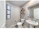 A modern powder room featuring stylish fixtures, a pedestal sink, and decorative wall art at 10979 Bristol Park Ave, Las Vegas, NV 89166