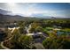 An aerial view showcases the community entrance near a golf course, surrounded by mature trees and desert landscape at 11830 Kingsbarns Ct, Las Vegas, NV 89141