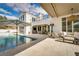 Resort-style backyard oasis with a sparkling pool, outdoor seating, and manicured landscaping at 11830 Kingsbarns Ct, Las Vegas, NV 89141