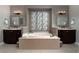 Well-appointed bathroom featuring a large soaking tub, dual vanities, and decorative mirrors for a luxurious feel at 11830 Kingsbarns Ct, Las Vegas, NV 89141