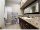 Cozy bathroom with granite countertops, dark cabinetry, and neutral tiling at 11830 Kingsbarns Ct, Las Vegas, NV 89141
