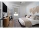 Cozy bedroom with modern furniture, macrame wall decor, stylish rug, and natural light from the window at 11830 Kingsbarns Ct, Las Vegas, NV 89141