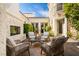 Backyard patio area featuring a fireplace, comfortable seating, and lush landscaping at 11830 Kingsbarns Ct, Las Vegas, NV 89141