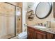 Stylish bathroom with a walk-in shower, granite countertop vanity, and decorative mirror at 1291 Rolling Sunset St, Henderson, NV 89052