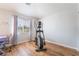 Exercise room with desk, chair, elliptical, and wood flooring at 1291 Rolling Sunset St, Henderson, NV 89052