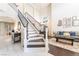 Grand staircase leading to the upper level with a view of the living room and foyer at 1291 Rolling Sunset St, Henderson, NV 89052