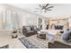 Open floor plan living room with tile floors, a fireplace, a ceiling fan, and access to the kitchen at 1291 Rolling Sunset St, Henderson, NV 89052