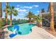 Private backyard boasts a sparkling swimming pool, mature palm trees, and outdoor seating areas, ideal for relaxation at 1291 Rolling Sunset St, Henderson, NV 89052