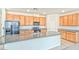 Kitchen featuring granite counters, wooden cabinets, an island, and modern appliances at 156 Fulgora St, Henderson, NV 89074