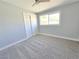 Bedroom showcasing neutral gray walls, carpet, a bright window and a closet with bi-fold doors at 1836 Mcdaniel St, North Las Vegas, NV 89030