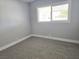 Cozy bedroom with neutral gray walls and carpet, bright natural light, and white trim at 1836 Mcdaniel St, North Las Vegas, NV 89030