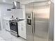 Contemporary kitchen with stainless steel refrigerator, sleek white cabinets, and modern range hood at 1836 Mcdaniel St, North Las Vegas, NV 89030