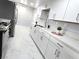 Well-lit kitchen featuring white cabinets, modern appliances, and a seamless countertop that extends into the sink area at 1836 Mcdaniel St, North Las Vegas, NV 89030