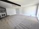 Bright living room featuring plush carpet, a stone fireplace, a ceiling fan, and a beamed ceiling at 1836 Mcdaniel St, North Las Vegas, NV 89030