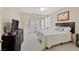 Cozy bedroom with a queen-sized bed, dresser with TV, bay window, and neutral decor at 2103 Poppywood Ave, Henderson, NV 89012