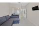 Cozy bedroom with a gray sectional, a wall-mounted tv, and mirrored closet at 2103 Poppywood Ave, Henderson, NV 89012