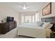 Bright bedroom with a ceiling fan, bay window, and a dark wood dresser at 2103 Poppywood Ave, Henderson, NV 89012