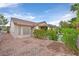 Charming exterior view with a gravel yard and lush green bushes at 2103 Poppywood Ave, Henderson, NV 89012