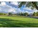 Beautiful golf course view showcasing lush green lawns and an elegant clubhouse against a partly cloudy sky at 2103 Poppywood Ave, Henderson, NV 89012