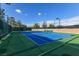 Outdoor tennis court featuring vibrant blue playing surface, green surround, and new lighting at 2103 Poppywood Ave, Henderson, NV 89012