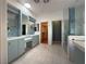 A spacious bathroom featuring double sinks, blue vanity, walk in closet and glass enclosed shower at 2138 Fort Halifax St, Henderson, NV 89052