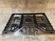 A close-up view reveals the cooktop's six burners and a modern design, nestled into the granite countertop with matching backsplash at 2138 Fort Halifax St, Henderson, NV 89052