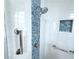 Bright, updated shower features white subway tile, blue mosaic accents, and grab bars for added safety at 2138 Fort Halifax St, Henderson, NV 89052