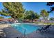 Community swimming pool with seating and view of mature trees providing shade at 227 N Lamb Blvd # B, Las Vegas, NV 89110