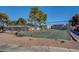 Community tennis and basketball court surrounded by mature trees and gravel area at 227 N Lamb Blvd # B, Las Vegas, NV 89110