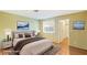 Bright bedroom features neutral walls, wood floors, large windows and closet, with decoratively staged furniture at 2380 Sierra Sunrise St, Las Vegas, NV 89156