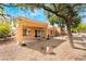Inviting backyard features desert landscaping, mature trees, covered patio, and large sliding glass doors at 2505 Showcase Dr, Las Vegas, NV 89134
