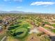 Breathtaking aerial view of a golf course surrounded by houses, with mountain views, showcasing the serene neighborhood at 2505 Showcase Dr, Las Vegas, NV 89134
