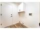 Bright laundry room featuring wood floors, utility hookups, and overhead white storage cabinet at 2505 Showcase Dr, Las Vegas, NV 89134