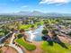 Overhead shot of a pond and fountain on the lush, green golf course surrounded by residential homes with mountain views at 2505 Showcase Dr, Las Vegas, NV 89134
