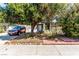 Charming single-story home with mature landscaping and a tree providing shade over the front yard and driveway at 2600 E Owens Ave, North Las Vegas, NV 89030
