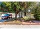 Charming single-story home with mature landscaping and a tree providing shade over the front yard and driveway at 2600 E Owens Ave, North Las Vegas, NV 89030