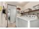 Bright laundry room with washer, dryer, shelving and view to hallway at 2600 E Owens Ave, North Las Vegas, NV 89030